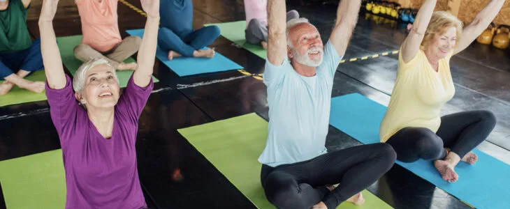 a group of seniors participating in a yoga or fitness class.